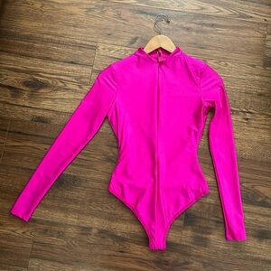 Skims fuchsia long sleeve bodysuit has two small dots in the front.